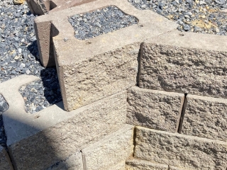 Compacted clean crush drainage gravel backfills SRW blocks.