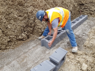 Ensuring the leveling pad and first course of retaining walls are level. Ensuring the leveling pad and first course of retaining walls are level.