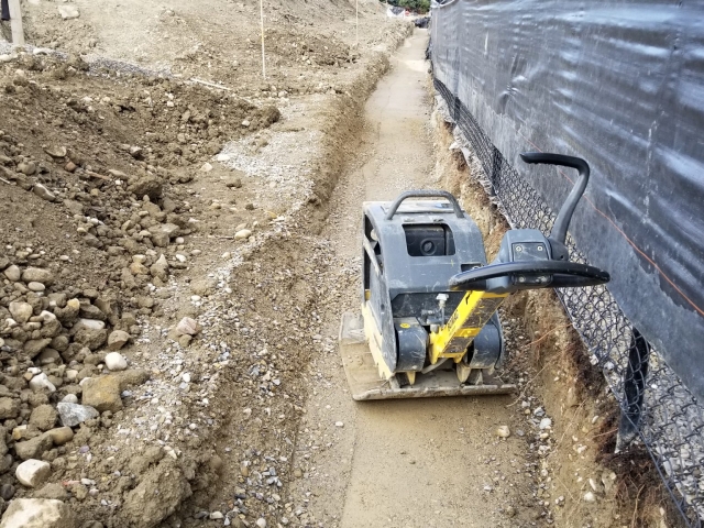 Retaining wall base pad preparation includes vital compaction.