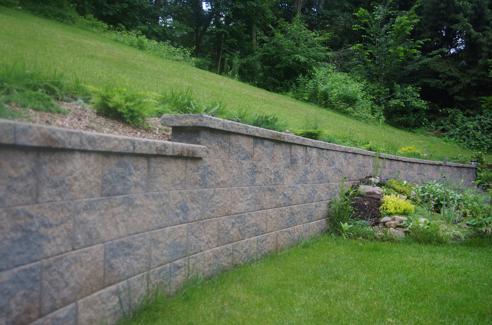 Cornerstone 100 retaining wall creates usable space below slope.